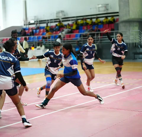 Match intense de kabaddi en cours, mettant en valeur l'agilité et le travail d'équipe sur le terrain Match intense de kabaddi en cours, mettant en valeur l’agilité et le travail d’équipe sur le terrain